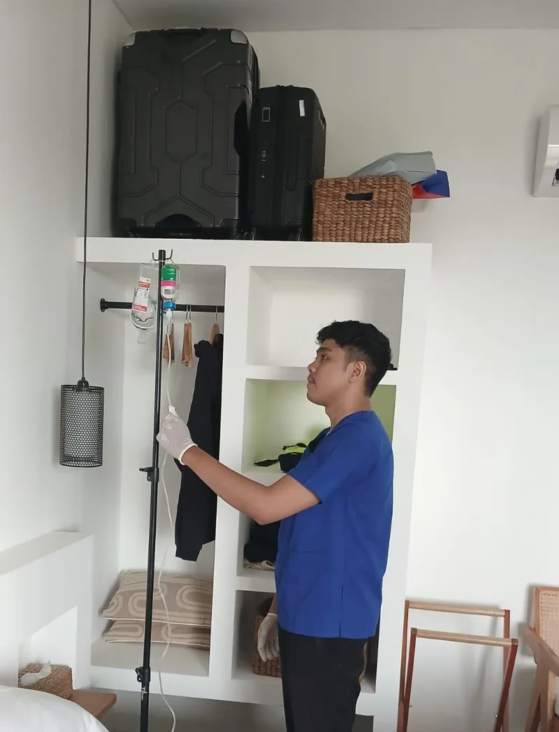 Nurse preparing an IV drip stand in a hotel room in Bali